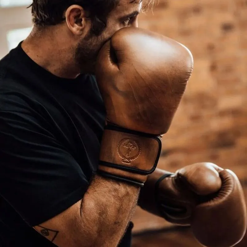 Man boxing with brown leather gloves during training